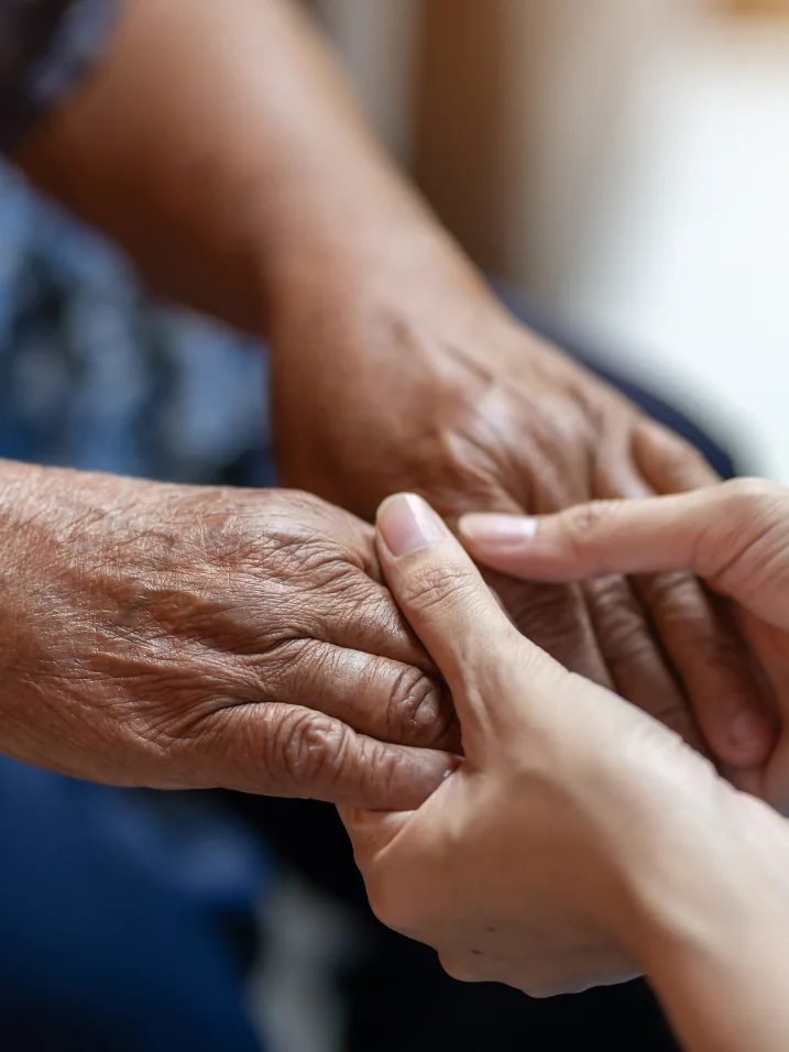 Younger hands holding an older patient’s hands